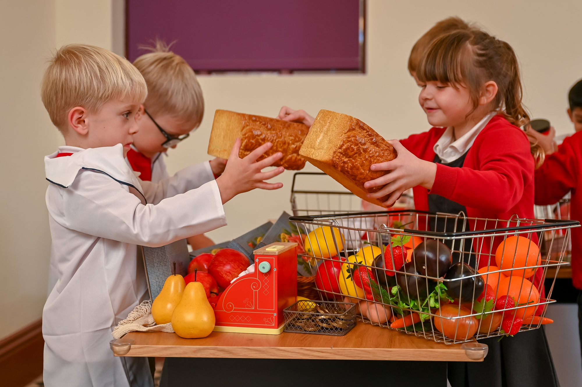 Early Years School Children enjoy playing with shops in a 1940s Co-op